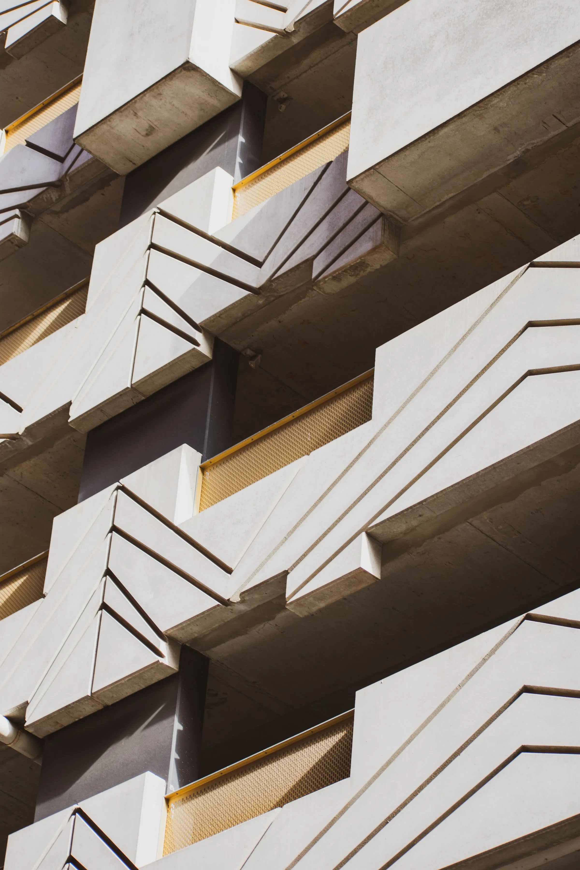 Close view of a concrete facade with repeating geometric lines.