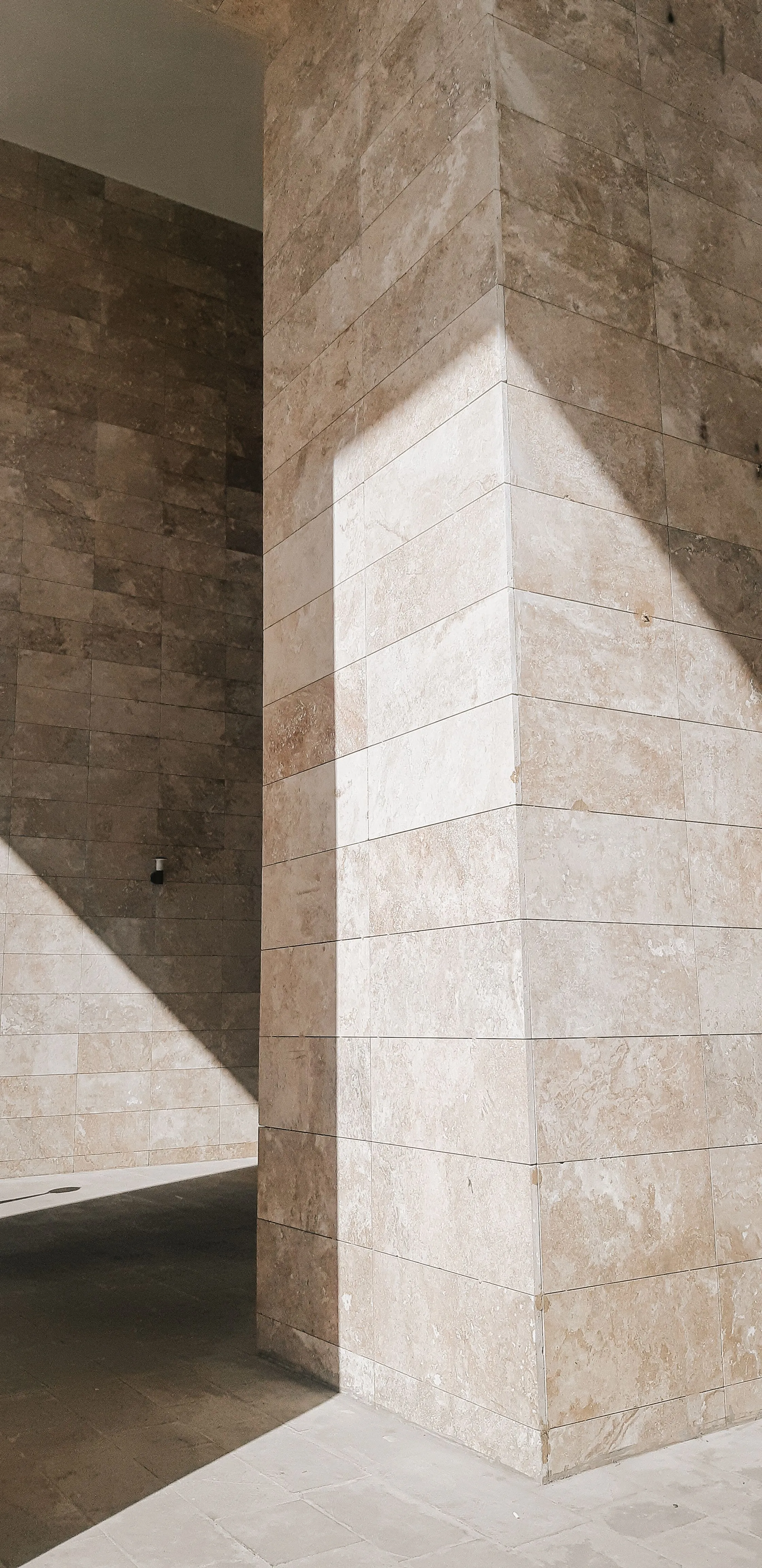 The corner of a stone building in strong light and shadow.